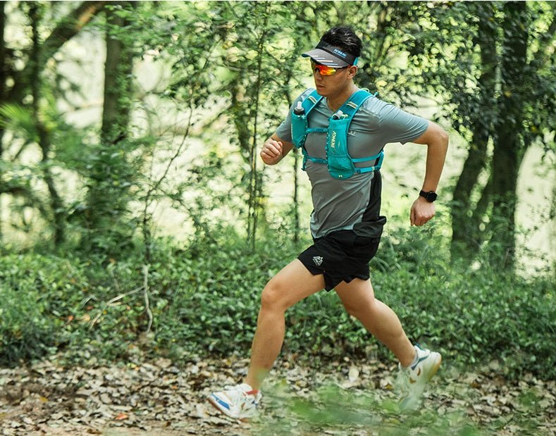 Quelqu'un en tenue de sport court sur un sentier forestier, portant un gilet d'hydratation bleu Aonijie C9107 en nylon élasthanne, ainsi que des lunettes de soleil et une visière.