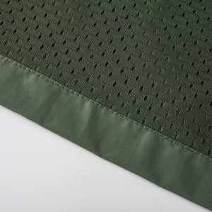 Gros plan d'un tissu en polyester perforé vert avec un ourlet cousu sur une surface blanche représentant la Veste de randonnée légère à capuche pour homme "King Billion - JK8689" de King Billion.